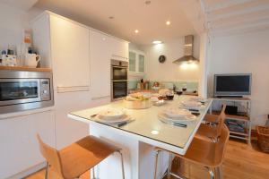 a kitchen with a table with chairs and a counter top at Vesta Cottage, Orford in Orford