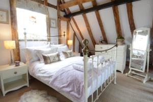 a bedroom with a white bed and a large window at Wassicks Cottage, Haughley in Haughley