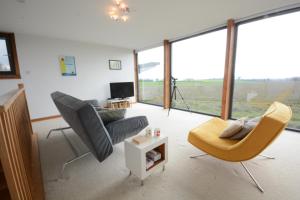 a living room with a couch and chairs and a tv at Upper Lodge, Shotley 