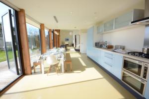 a kitchen with a table and a dining room at Upper Lodge, Shotley 