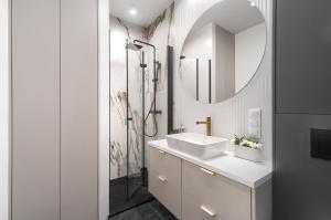 a bathroom with a sink and a mirror at MARGI Aicon VERY COZY OLD TOWN STUDIO in Szczecin
