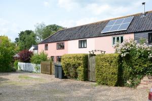 a pink house with solar panels on the roof at Seafarers in Fressingfield