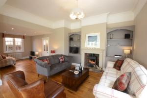 ein Wohnzimmer mit 2 Sofas und einem Kamin in der Unterkunft Holly Lodge in Aldeburgh