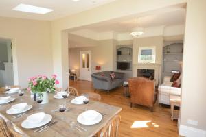ein Esszimmer und ein Wohnzimmer mit einem Tisch in der Unterkunft Holly Lodge in Aldeburgh