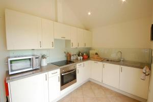 a kitchen with white cabinets and a microwave at Remus in Larling