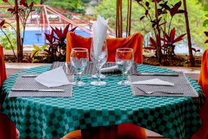 un tavolo verde e bianco con bicchieri da vino sopra di Kiriri Residence Hotel a Bujumbura