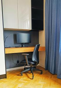 einen Schreibtisch mit einem Stuhl und einem Computermonitor in der Unterkunft Studio Nowolipki, City Center in Warschau