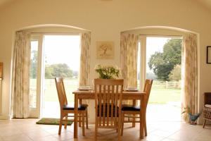 a dining room with a table and chairs and windows at Romulus 