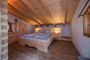 ein Schlafzimmer mit einem großen Holzbett und Holzböden in der Unterkunft Ferienhütte Sternenblick in Großkirchheim