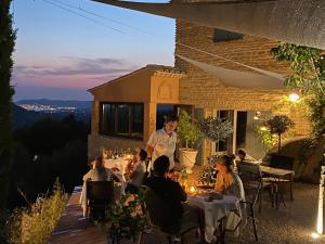 un gruppo di persone seduti ai tavoli in un ristorante di notte di La Bastide du Beausset-Vieux a Le Beausset