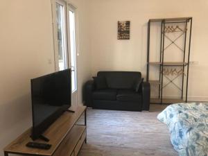 - un salon avec un canapé et une télévision dans l'établissement Appartements Saint Gratien 3 min à pied transport Tour Eiffel, à Saint-Gratien