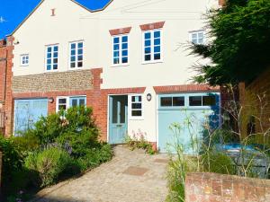 ein Haus mit blauen Garagentüren davor in der Unterkunft Seawall Cottage, Aldeburgh in Aldeburgh