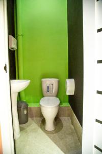 a green bathroom with a toilet and a sink at WakeUp Bishkek in Bishkek +11 photos