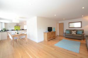 a living room and kitchen with a couch and a table at Southwold Arms Apartment in Southwold