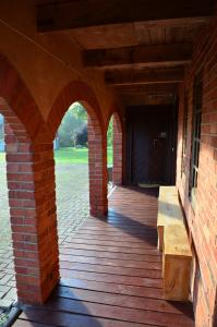 an outside porch of a brick building with a wooden deck at Putraimi. in Princmuiza