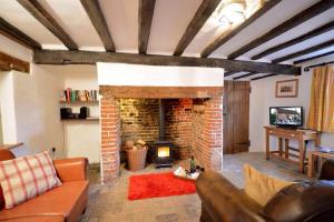 a living room with a brick fireplace and a couch at 1 Grange Cottages, Westleton in Westleton