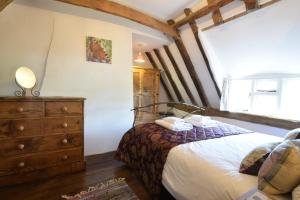 a bedroom with a bed and a wooden dresser at 1 Grange Cottages, Westleton in Westleton