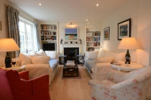 a living room with white furniture and a fireplace at 2 The Bays, Thorpeness in Thorpeness