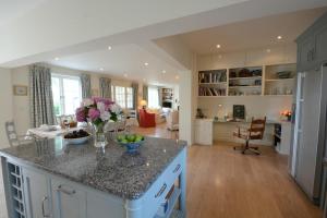 a kitchen and living room with a vase of flowers on a counter at 2 The Bays, Thorpeness in Thorpeness