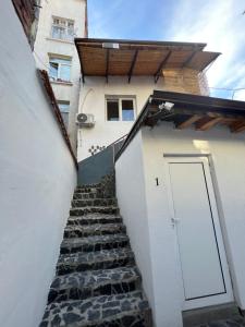 uma escada que conduz a um edifício branco com uma porta em The rainbow 4 em Sófia