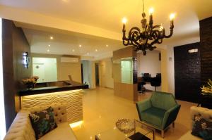 a living room with a couch and a chandelier at Dom Hotel in Piura