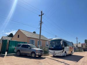 ein Auto und ein Bus, der neben einem Haus parkt in der Unterkunft Guesthouse Gulmira in Bokonbayevo