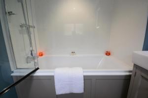a bathroom with a bath tub with a towel at 1 The Old Coach House in Laxfield +11 photos