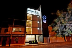 un bâtiment avec une horloge sur son côté dans l'établissement Dom Hotel, à Piura