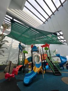 a play area with a playground with slides and swings at River Place in Singapore
