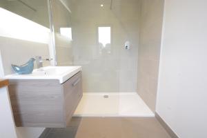 a white bathroom with a sink and a shower at Rush House, Eastbridge in Westleton