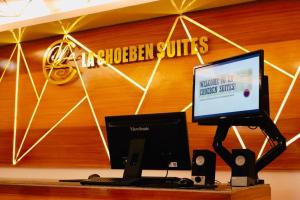 un ordenador en un escritorio con ordenador portátil y altavoces en La Choeben Suites, en Calbayog