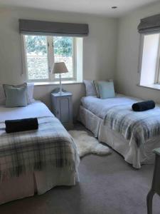a bedroom with two beds and a lamp in it at LOBSTER COTTAGE (Norfolk Costal Cottage) in Langham