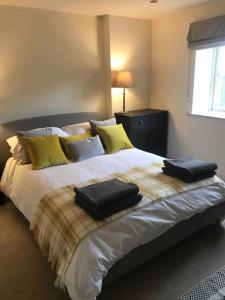 a bedroom with a bed with two towels on it at LOBSTER COTTAGE (Norfolk Costal Cottage) in Langham