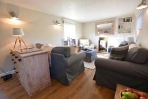 a living room with two couches and a table at Little Turnpike Cottage, Melton in Woodbridge