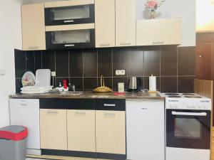 una cocina con electrodomésticos blancos y azulejos marrones en Apartman SkiBeg, Vlašić, en Vlašić