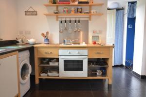 una cucina con piano cottura, lavandino e lavatrice di Pudding Cottage, Westleton a Westleton