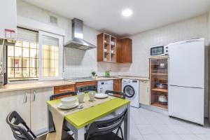 a kitchen with a green table and a refrigerator at Retiro VII in Madrid