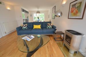 a living room with a blue couch and a tv at Aldeburgh Lodge Gardens in Aldeburgh +13 photos