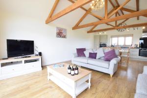 a living room with a couch and a tv at The Mulberry, nr Bungay in Bungay