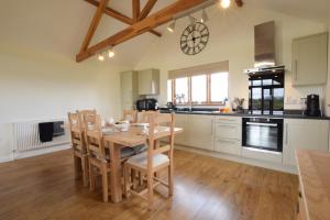 a kitchen with a wooden dining room table and chairs at The Mulberry, nr Bungay in Bungay