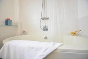 een wit bad met een witte handdoek erop bij Aldeburgh Lodge Gardens in Aldeburgh