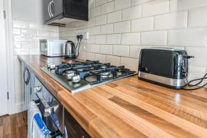 a kitchen counter with a stove and a microwave at Cool and Chic Duffield Road Apartments in Derby