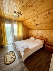 a bedroom with a bed in a wooden cabin at Cabana 7 Brazi in Poiana Mărului