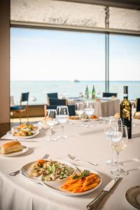 a table with plates of food and wine glasses at Hotel Royal Continental in Naples