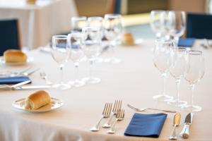 a table with wine glasses and a plate of bread at Hotel Royal Continental in Naples