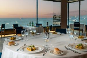 a table with plates of food and wine glasses at Hotel Royal Continental in Naples