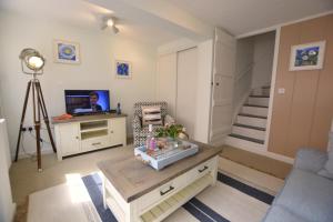 Una sala de estar con un sofá, una mesa y un televisor. en Alinka, Aldeburgh, en Aldeburgh