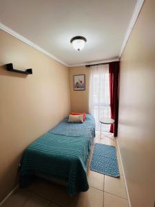 Habitación pequeña con cama y ventana en Apart Mejillones - Dpto 24, en Mejillones