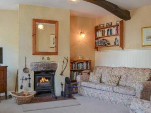 a living room with a couch and a fireplace at Old Saddlers Cottage in Ireby