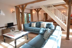 a living room with a blue couch and a table at Wheelwright's Barn in Halesworth